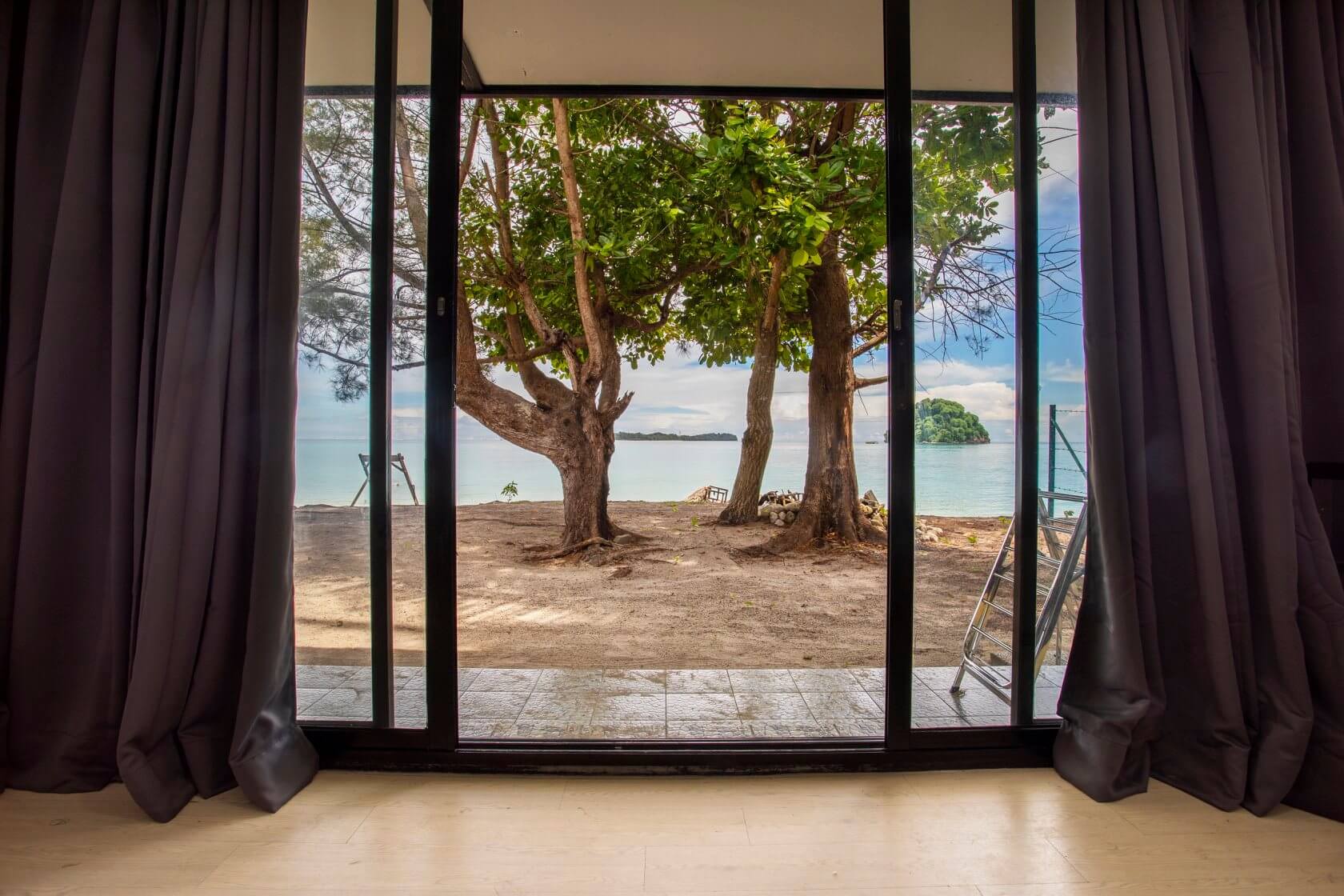 Full-length window with garden and beach view can be seen from your room